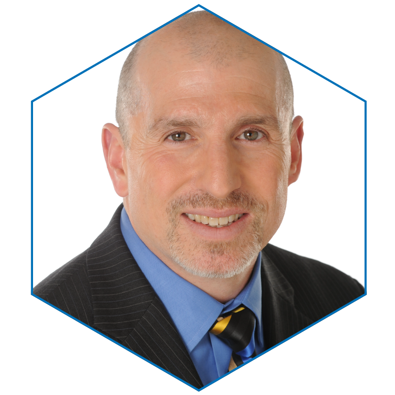 headshot of Adrian Boros, CTO, from the shoulders up. He has dark hair, a light beard, dark eyes, caucasian skin, and is wearing a dark jacket over a blue collared shirt