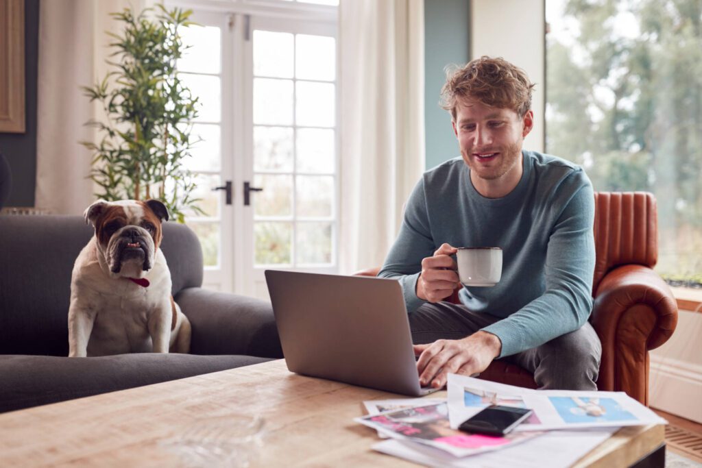 A hero image of a Man Working From Home With Pet Bulldog