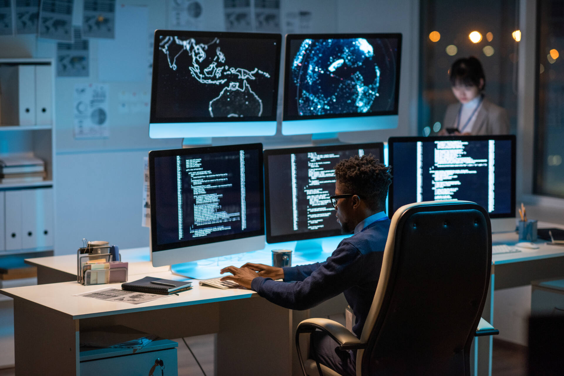 A hero image of a cyber security manager sitting at a desk in front of computer monitors