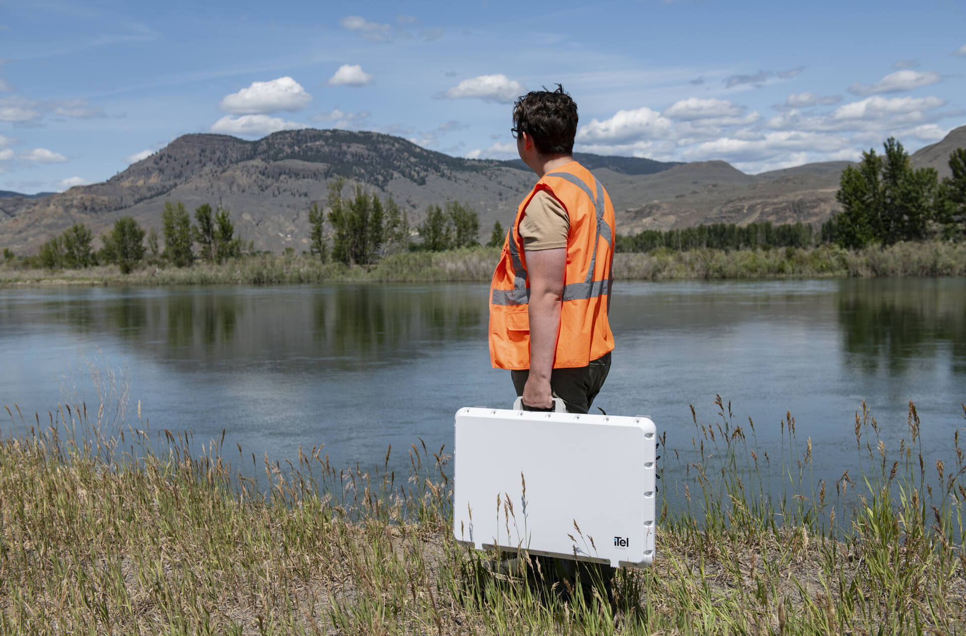 iTel iLink in Action – Enterprise Connectivity on the Move Field technician carrying iTel iLink connectivity unit near remote water site